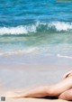 A woman laying on the beach with her legs crossed.