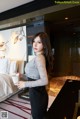 A woman standing in a hotel room holding a cup of coffee.