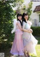 Two young women standing next to each other in dresses.
