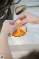 A person is peeling an egg into a bowl.