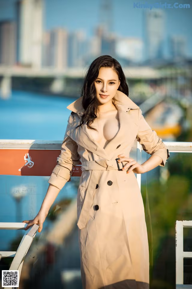 A woman in a trench coat posing for a picture.